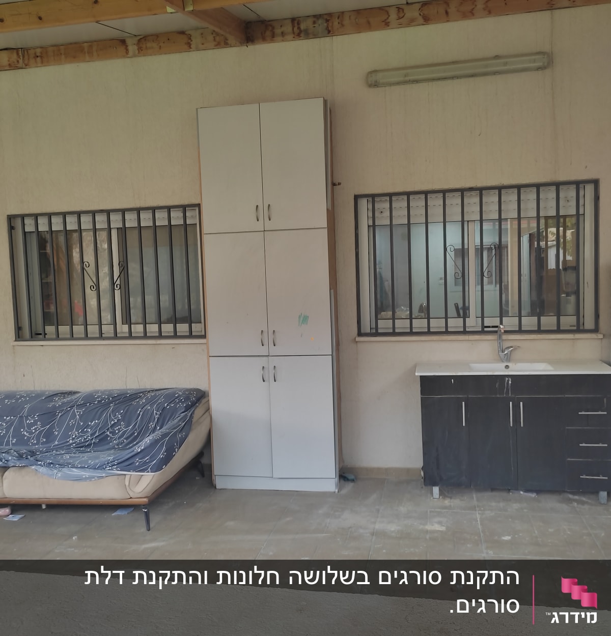 שני חלונות עם סורגים על קיר חיצוני